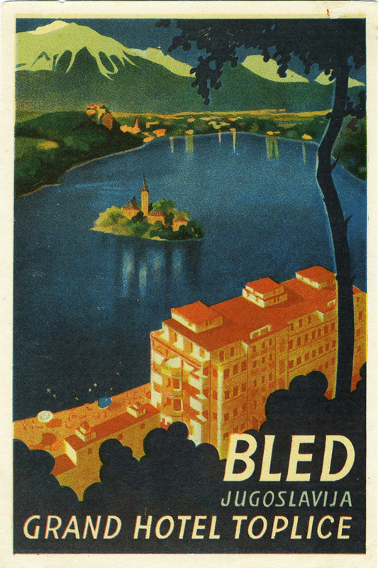 View of Lake Bled and hotel through trees; blue, red, white