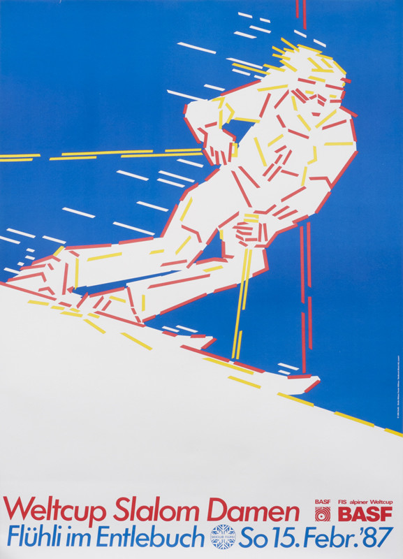 Skier in motion againt blue sky; blue, white, orange