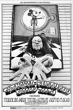 No. 192, mickey mouse clock behind a photograph of stanley mouse, Buddy Guy, Spooky Tooth; black and white