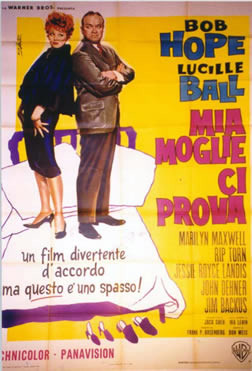 Bob Hope & Lucille Ball stand back to back on bed; yellow, pink, blue