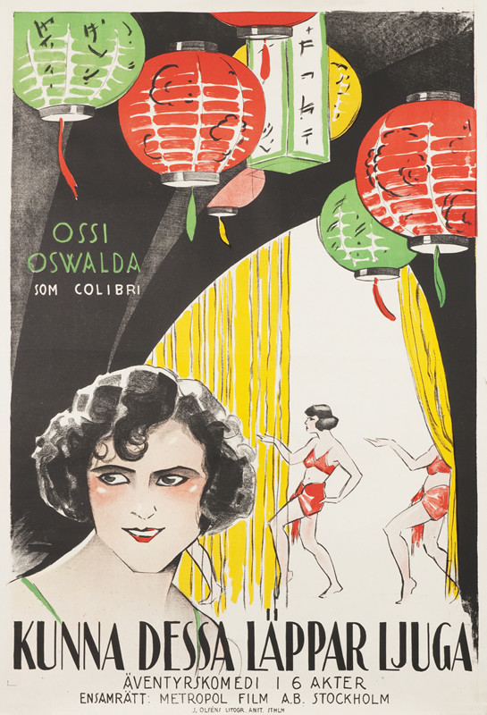 Ossi Oswalda close up, girls behind doing the Egyptian dance underneath paper lanterns; black, yellow, green