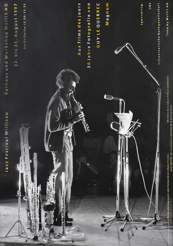 Image of musician playing soprano saxophone onstage; black, white, yellow, gray
