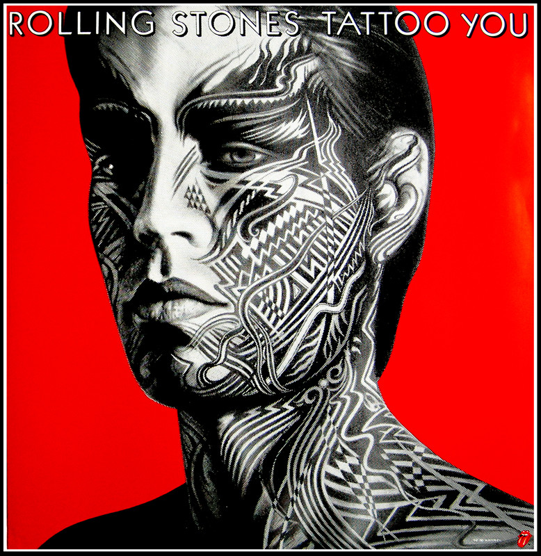 Close up view of Mick Jagger's' head in profile, covered in tattoos; red, black, white