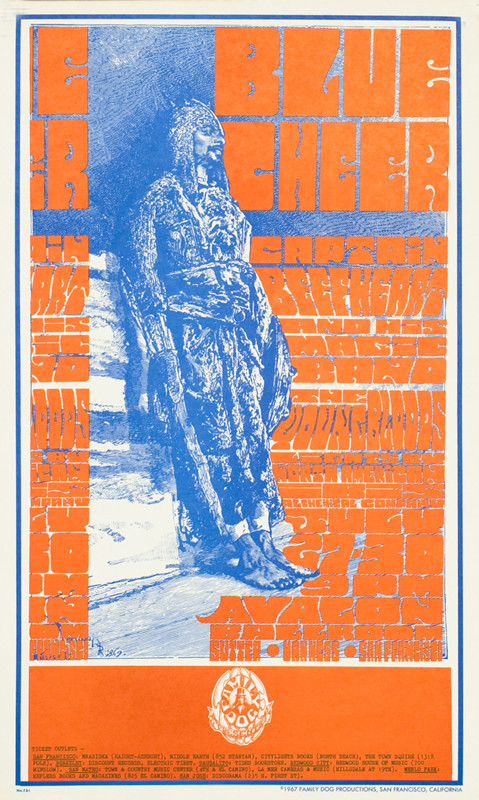 Arabian solider leans against wall; blue, white, orange