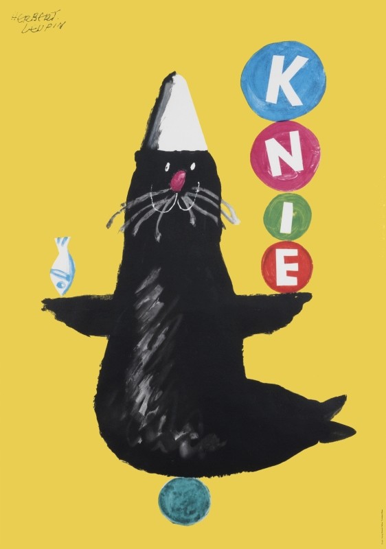 Cartoon seal balancing four balls each having a letter that spells out KNIE;  yellow, black, white, pink, green