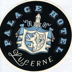 Parted draperies unveil a royal crest with lion; black, blue, white