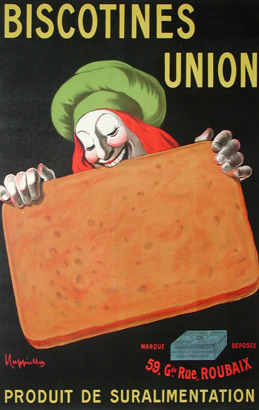 Man with red hair and green cap takes bite of huge cookie biscuit; black, orange, brown