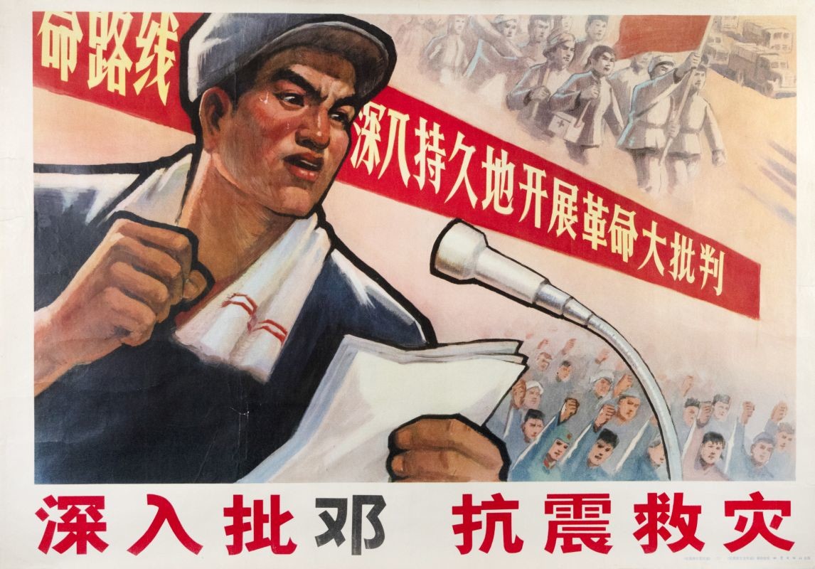 Man speaking into microphone, with crowds in background; red, pink, blue