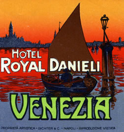 View of Venice at sunset from water, sailboat; red, blue, green, orange