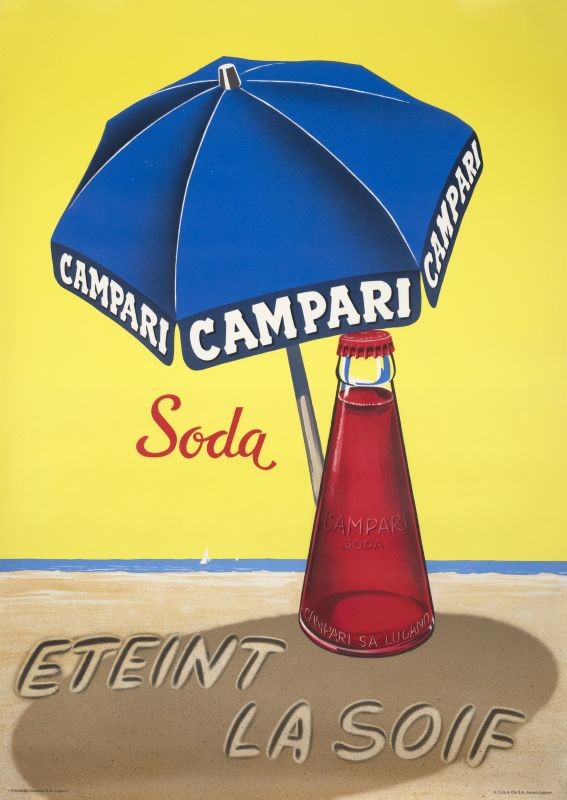 Campari bottle on beach under umbrella with text written in the sand; red, yellow, blue, beige